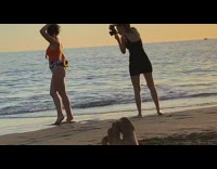 Girl poses with papaya on beach pt. 2