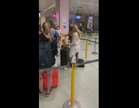 Woman white sweater take pictures of her pet on the luggage