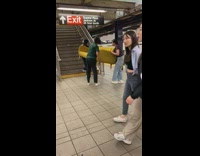 Three women carry sofa subway station stairs