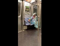 Man dressed in blue baby infant halloween costumer puts legs up on seat on subway train