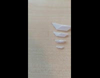 Very small paper boat compared to coin