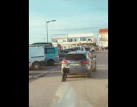 Car drives with wetsuit sticking out trunk 