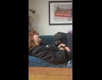 GIrl laying on blue couch singing black dog is bothered