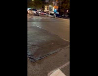 Man glowing outfit rides scooter on road