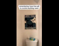 Woman shows crochet poster of cats