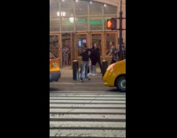 Man plays the trombone on the sidewalk