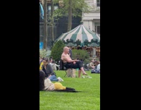 Shirtless guy sits on chair at park 