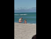 Man with colorful sleeves poses at the beach