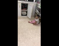 baby in pink opens cabinet and falls