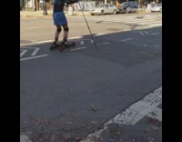 Guy rollerblades down street with ski poles 
