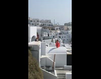 Girl orange dress hold skirt  santorini roof