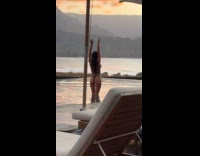 Woman bikini films with camera on tripod