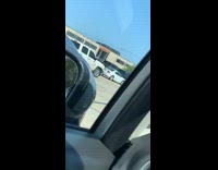 Guy cutting friends hair parking lot 