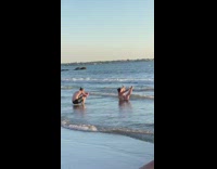 Girl sits ocean water lifts both legs 