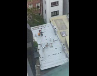 Guys film robot play with toy plane rooftop