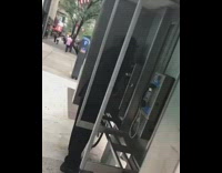 Man in business suit calls and argues with cheating wife over a payphone in public