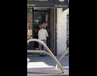 Man with dog on shoulder pets cat