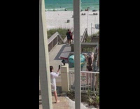 Woman take outdoor shower beach stairs swimsuit 