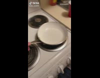 Guy spits egg into white pan 