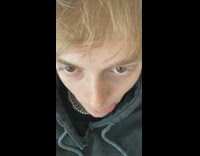 Blonde guy sticks out tongue paints black trash bag 