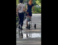 Man pushes injured woman on the scooter