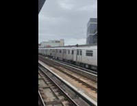 Two guys running on top of a subway train as it is departing