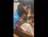 Man snake on head sits on bench