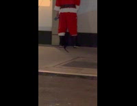 Man Santa costume pee beside building street