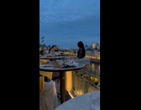 Woman black top poses at restaurant balcony