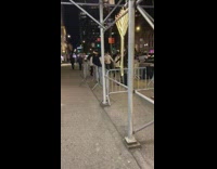 Guys dance by large menorah decoration outside 