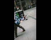 Man with Trump mask lies on sidewalk with Wall Fund cup