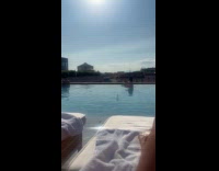 Woman selfie beside men with phone at pool