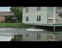 Skater jumps off stairs balcony from blue building and jumps into lake 