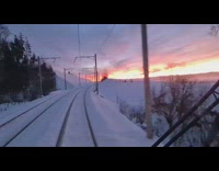 Train goes across tracks outside snow sunset 