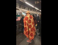 Guy dressed head to toe in pepperoni pizza outfit at subway station, cape mask, hat, gloves, pants
