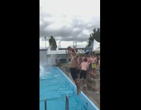 Guys jump and dive into pool water 