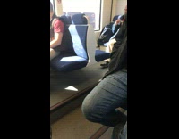 Man clips his fingernails on the back of a bus