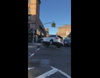 white suv stuck and tipped over on street
