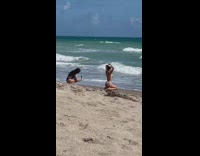 Woman green bikini kneel fix hair beach