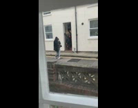 Girl black jacket poses doorway white building  