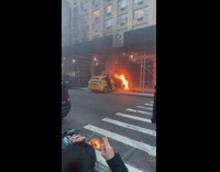 Taxi that crashed into building on fire and explodes