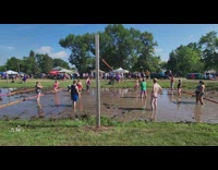 Group of people play volleyball in the mud