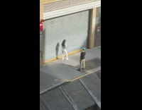 Woman white pants photo shoot closed steel door sidewalk