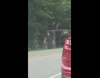 Man help old man from flipped truck