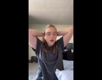 Girl in bed wakes up and ties up hair 