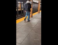 Man walks train platform wears rat slippers