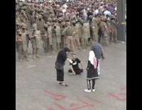 Guy black shirt sit ground soldiers protest