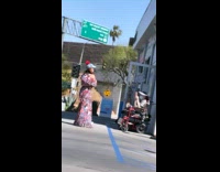 Woman floral dress poses elderly woman on a wheelchair take picture