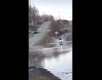 Guy rides yellow snowmobile through flood water