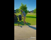 Guy mows lawn with golden retriever dog 